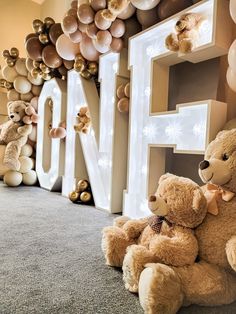 two teddy bears are sitting in front of balloons and letters that spell out the word love