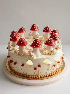 a white cake topped with lots of red mushrooms