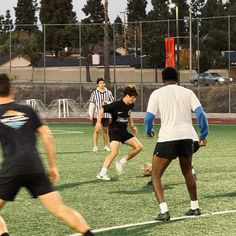 a group of people are playing soccer on a field with other people in the background