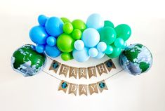 an earth day banner with balloons and streamers