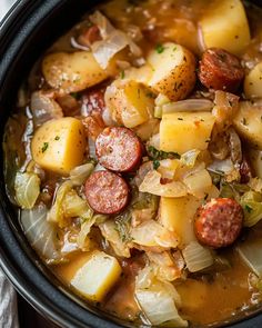 a close up of a bowl of food with potatoes and sausage