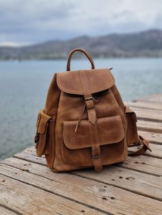 Leather Backpack in waxed brown with side pockets and many compartments in variety of colours and sizes. It's  the ideal Backpack for students and perfect for your travels. All bags are handmade of real Greek leather and brass accessories. The straps are adjustable.   The bag in the picture is a medium (28×34×15 cm) MIND THAT THE COLOURS SOMETIMES MAYBE BE A LITTLE BIT DIFFERENT. All Bags are made to order. If you like this bag, please see our full collection in the below link: https://www.etsy. Brown Waxed Finish Satchel For School, Brown School Satchel With Pockets, Brown Satchel With Pockets For School, Brown Bags With Multiple Pockets For Outdoor Activities, Leather School Backpack With Pockets, Brown Backpack With Pockets For Everyday Use, Waxed Finish Satchel Backpack For School, Brown School Backpack With Pockets, Brown Shoulder Bag With Pockets For Adventure