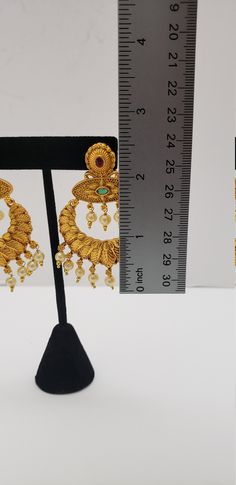 This beautiful earrings set has an excellent finish and gives out an exquisite sense of style. If you are looking for an amazing Fashion Jewelry set for special occasions such as Anniversary, Engagement, Party, Wedding, or for gifting, then your search ends here. Handmade Indian Temple Jewelry, best to wear it for traditional ceremonies or Indian wedding. This bridal jewelry has an ethnic finish. It has Cubic Zircon stones with semi-precious ruby and emeralds. It is a Bollywood style one gram je Gold Round Temple Jewelry Pearl Earrings, Intricate Temple Jewelry Style Pearl Earrings, Gold Chandbalis For Wedding, Gold Round Pearl Earrings In Temple Jewelry Style, Heavy Gold Pearl Earrings For Wedding, Traditional Gold Pearl Earrings For Wedding, Elegant Heavy Gold Pearl Earrings, Heavy Gold Pearl Earrings For Festive Occasions, Festive Gold Temple Jewelry Pearl Earrings