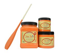 three jars of orange colored paste with a wooden spoon