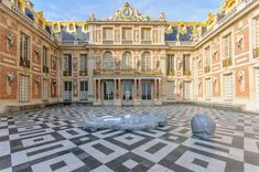 a large building with two sculptures in the middle of it's floor and windows