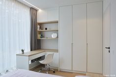 an empty bedroom with white furniture and curtains on the window sill, next to a bed