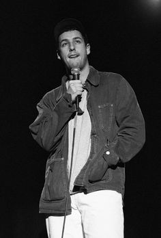 a black and white photo of a man holding a microphone