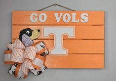 a wooden sign that says go volls with a dog on it and a bow