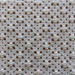 a close up view of a white fabric with holes in the center and small circles on it