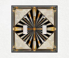 an art deco light switch plate cover in black, gold and white with two lights