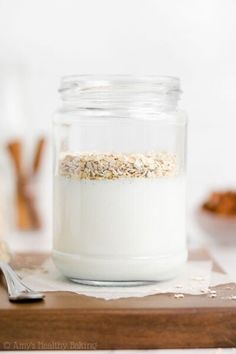 a glass jar filled with oatmeal sitting on top of a wooden cutting board