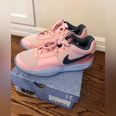 a pair of pink nike shoes sitting on top of a box