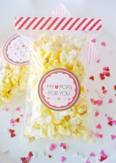 two bags filled with popcorn sitting on top of a white plate