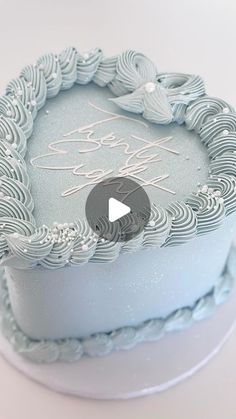 a blue cake with white frosting and a video playing on it's screen