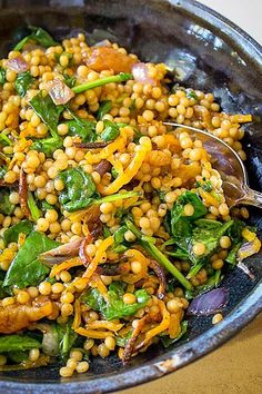 a bowl full of food that includes spinach, carrots and other veggies