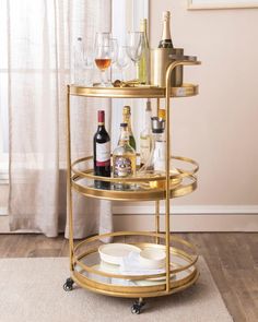 a gold bar cart filled with bottles and glasses