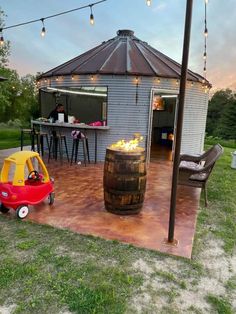 a small child's toy car sits in front of a barrel on the patio