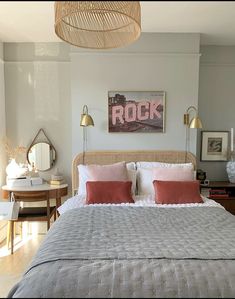 a bedroom with a bed, two lamps and pictures on the wall above it that says rock