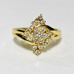 a yellow gold ring with two rows of diamonds in the shape of a flower, on a white surface