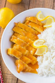 chicken with lemon sauce and rice on a white plate