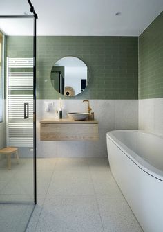 a bathroom with a tub, sink and mirror