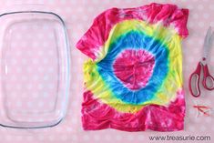 a tie - dyed shirt and scissors are sitting on a pink polka dot tablecloth