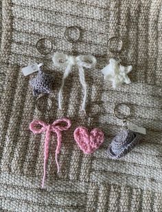 four crocheted keychains with hearts and bows on them sitting next to each other