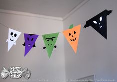 halloween bunting with paper bats and jack o lantern faces hanging from the ceiling in a room