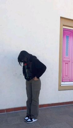 a person standing in front of a pink door