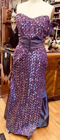 Could this gown be any more fabulous?  We think not.  The rich purple strapless sequined column gown has a ruched cummerbund, 2 inverted ruffles in the back and a train and bustle all made of lustrous taffeta.  There is a satin lining, and between the lining and the gown there is a tuille crinoline.  15" back zipper.  In VERY good condition. Bust 36" Waist 28" Hips 40" Length 11" from top of bodice to waist; 53" total Jessica Mcclintock, Column Gown, A Train, Ruffles, Dress Clothes For Women, Bodice, Satin, Dress Outfits, Bathing Beauties