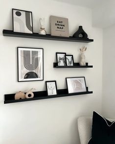 some black shelves with pictures on them in a living room or dining room are shown