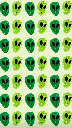 green alien heads with black eyes on a light green background seamless textured wallpaper