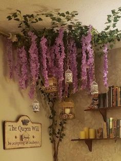 purple wister hanging from the ceiling in a room with bookshelves and shelves