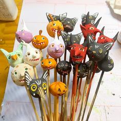 there are many halloween decorations on sticks in the shape of cats and pumpkins with faces