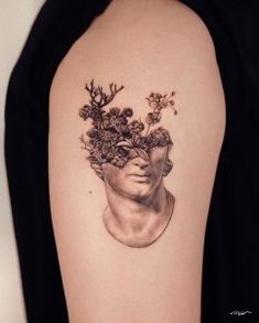 a woman's face with flowers in her hair on the back of her arm