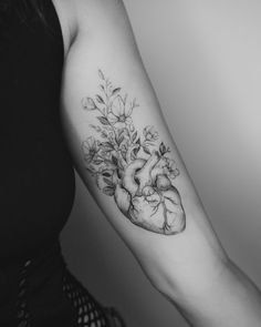 a woman's arm with flowers and a heart tattoo on it