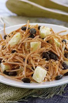 a white plate topped with pasta and raisins