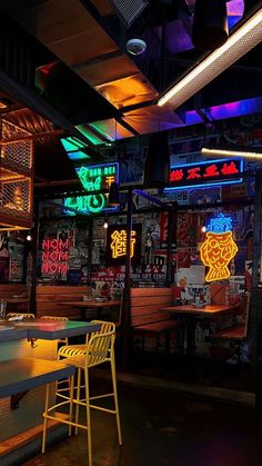 an empty restaurant with neon signs on the walls