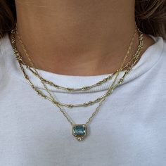 This Mazza bezel set pendant necklace features an emerald-cut aquamarine and a round diamond accent centered on a delicate Mariner-style chain in 14K yellow gold. Aquamarine Total Weight: 2.75 ct Diamond Total Weight: 0.05 ct Length: 16"