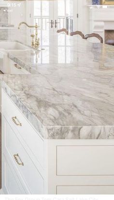 a kitchen with marble counter tops and white cabinets