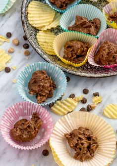 several cups filled with chocolate and peanut butter on top of a table next to other cupcakes