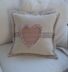 a pillow with a heart on it sitting on a chair