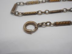 Offered is a wonderful 12 inch pocket watch chain fob. The chain has detailed gold links surrounded by silver outline. This can be worn with both a gold and silver pocket watch and looks amazing! Please note that we only sell original antiques. We do not alter, replace, repair, or re-purpose; and we do not sell reproductions. Buy with confidence that you are receiving the real thing! Please also note that we do not polish the jewelry because many of our customers prefer their jewelry with patina Vintage Silver Pocket Watch With Chain, Gold Metal Pocket Watch With Chain, Gold Pocket Watch With Chain For Formal Occasions, Victorian Pocket Watch, Silver Pocket Watch, Vintage Pocket Watch, Pocket Watch Chain, Gilded Age, Chain Extenders