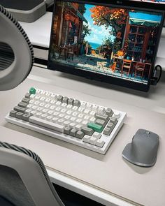 a computer keyboard sitting on top of a white desk next to a mouse and monitor