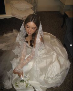 a woman in a wedding dress sitting on the floor