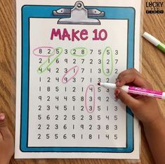 a child's hand writing on a calendar with markers