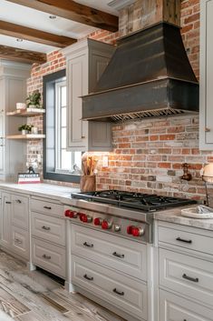 a kitchen with white cabinets and brick wall