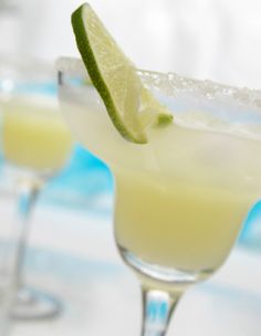 two margaritas with lime and salt garnish on the rim