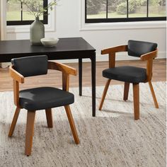 a dining room table with two chairs and a vase