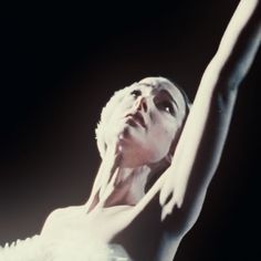 a woman in white is holding her arms up